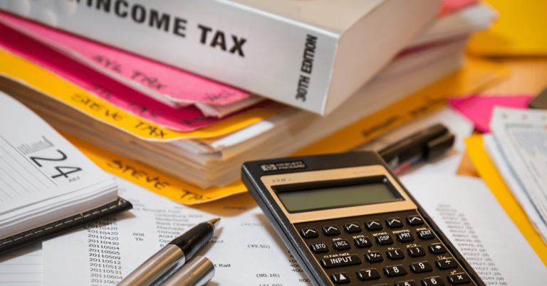 calculadora, livros de taxas e papéis