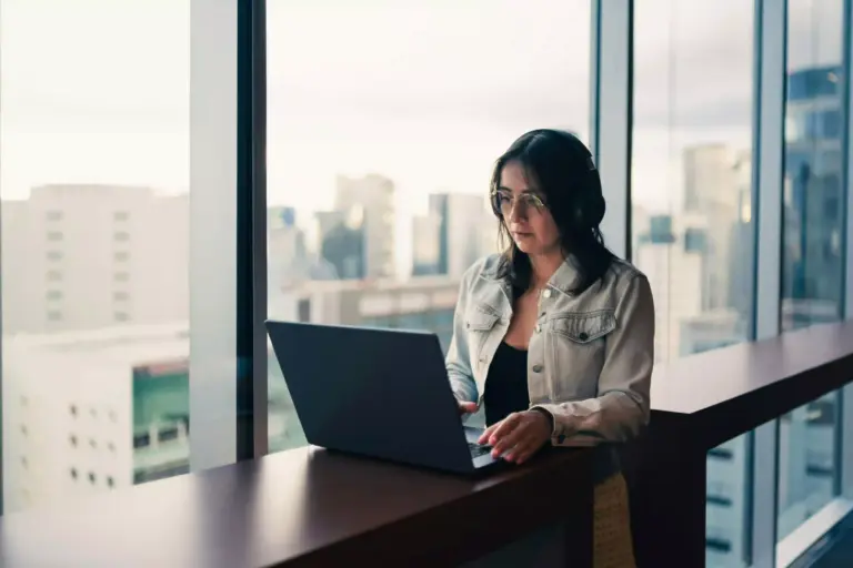 Imagem de uma mulher utilizando um notebook para se informar sobre a lei de zoneamento em São Paulo.