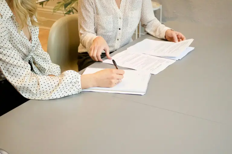 Foto de duas mulheres analisando documentos