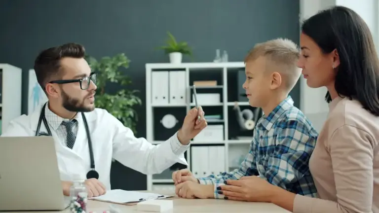 Médico examinando uma criança durante consulta, acompanhado pela mãe.